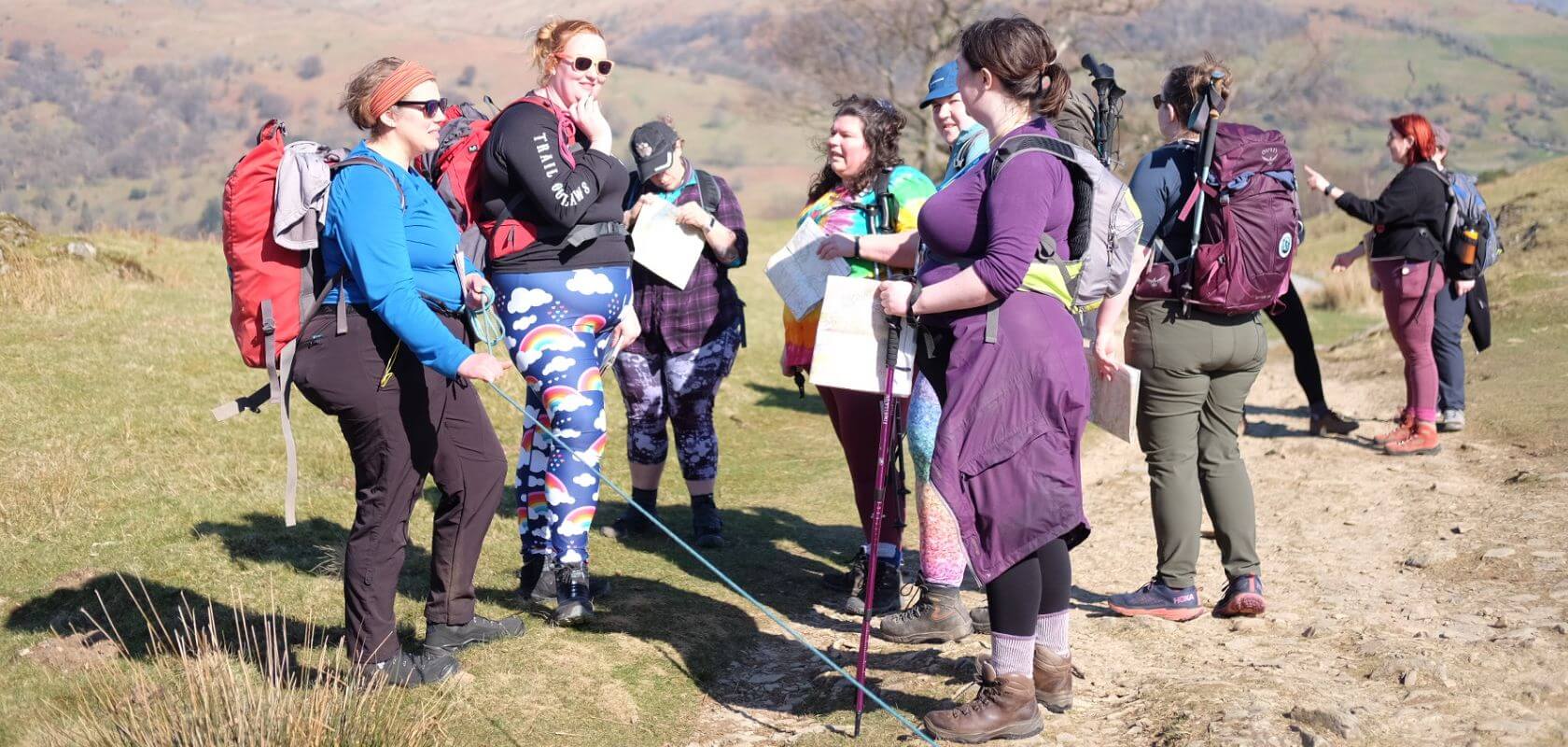 Women stood together in nature taking a break from a hike in the wild.