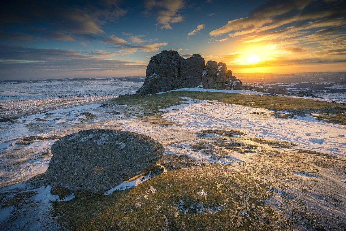 A rock formation in a snowy field