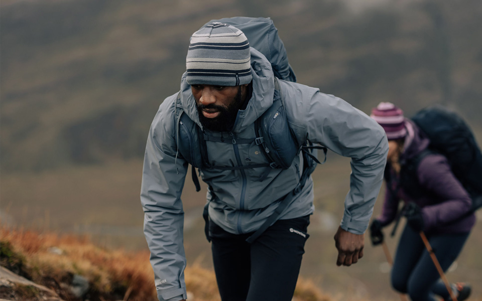 Two people hiking up a hill with Montane clothing 