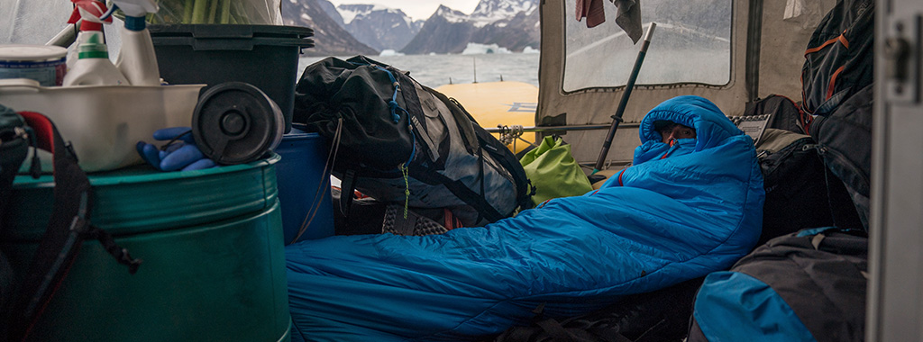 A person wrapped up in a bright blue sleeping bag