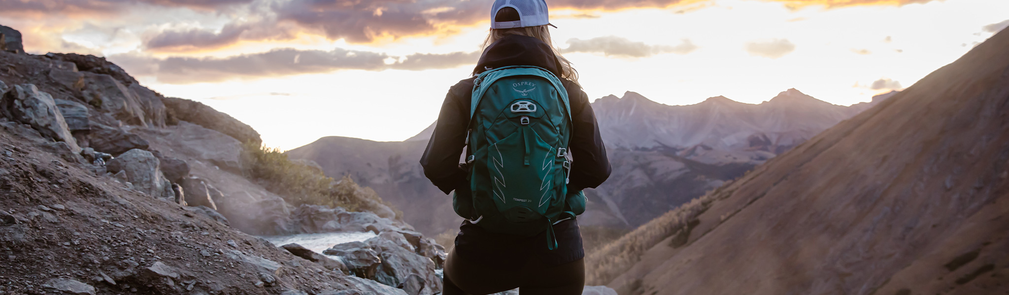 A person looking out to the mountains wearing an Osprey daypack 