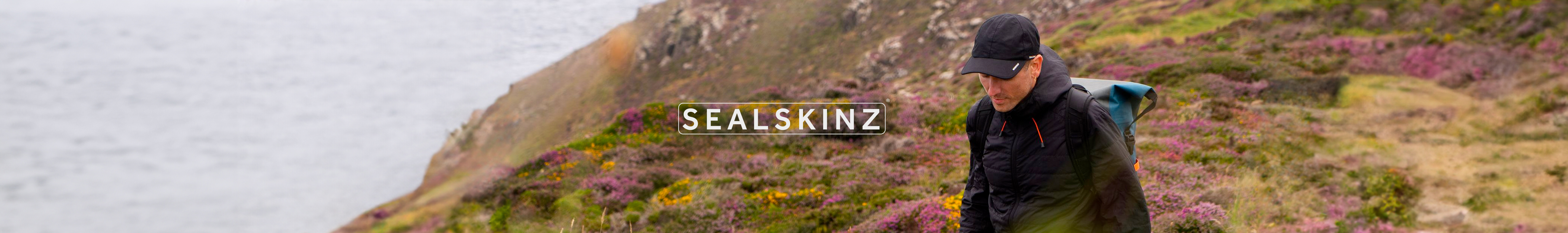 man walking wearing products from Sealskinz with Sealskinz logo in the centre