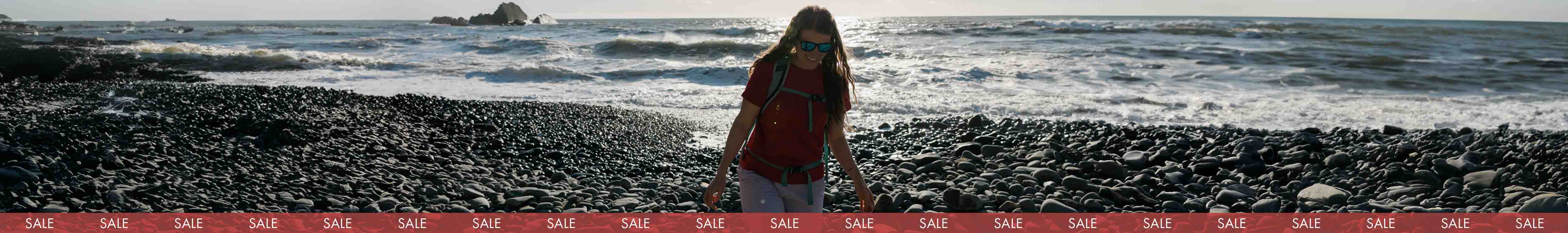 woman stood by sea front wearing shorts and tshirt 