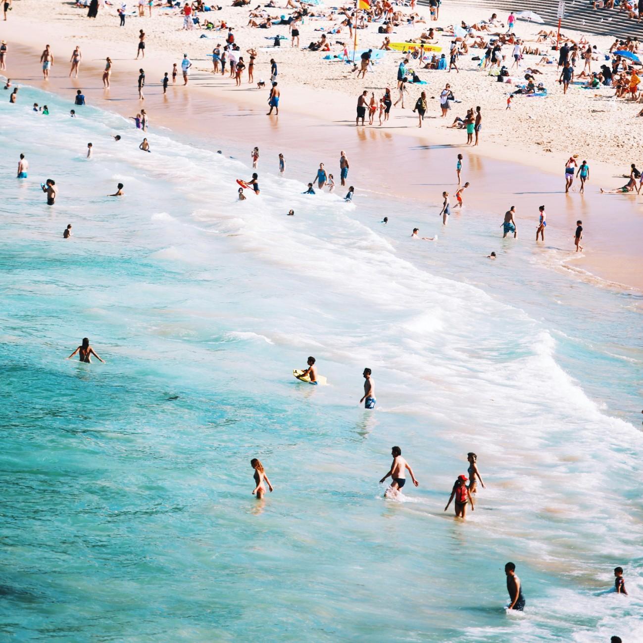 Lots of people in the sea and on the shore of Bondi Beach