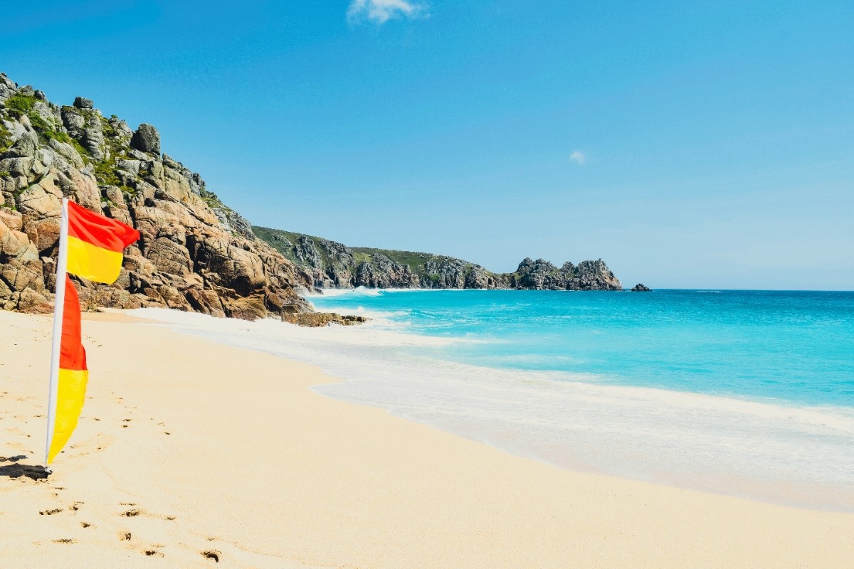 Porthcurno beach with a lifeguard flag in the sand