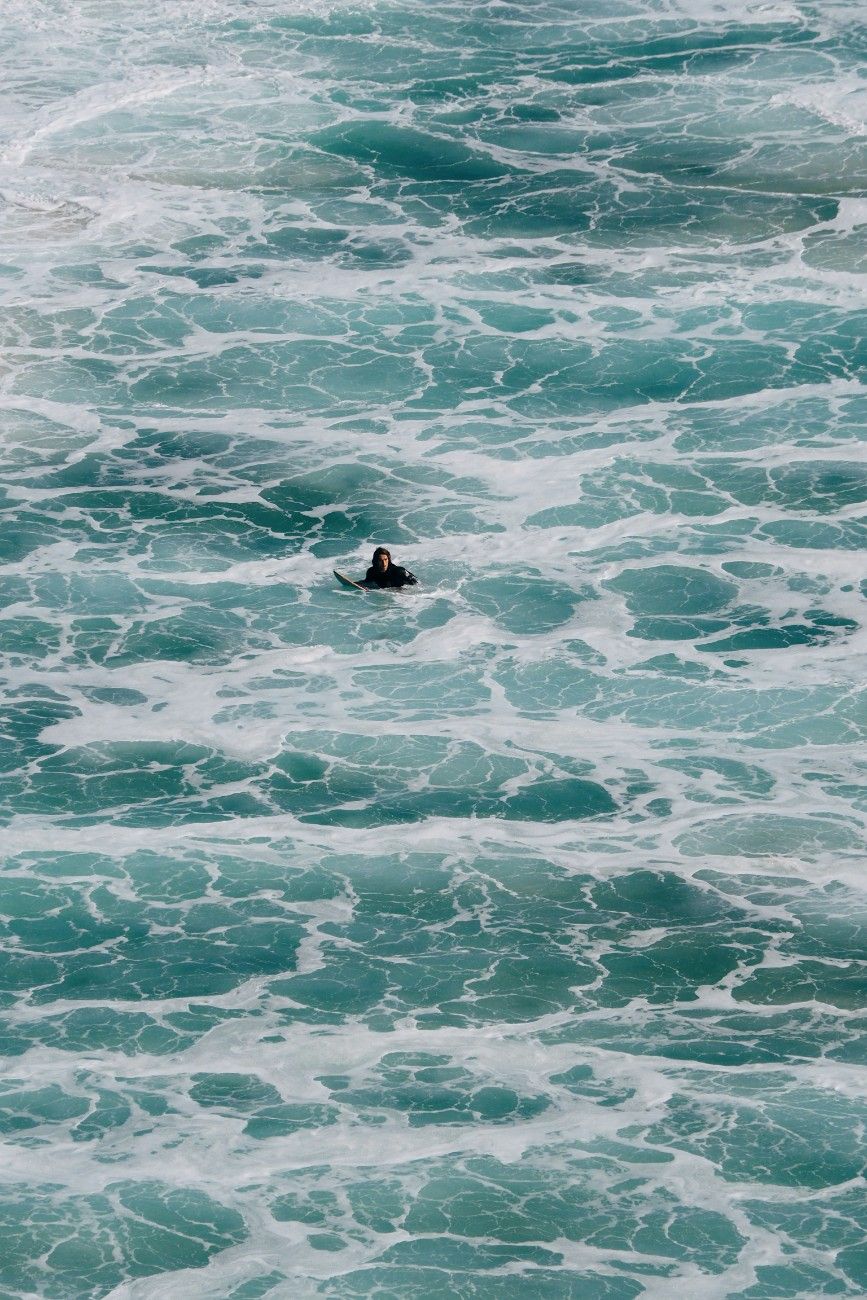 A surfer at Porthcurno beach