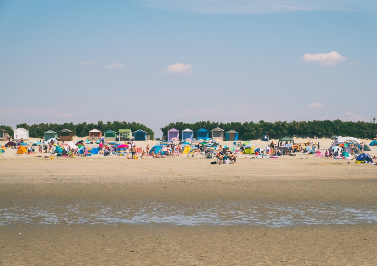 West Wittering Beach on a busy day, with beach huts in the background