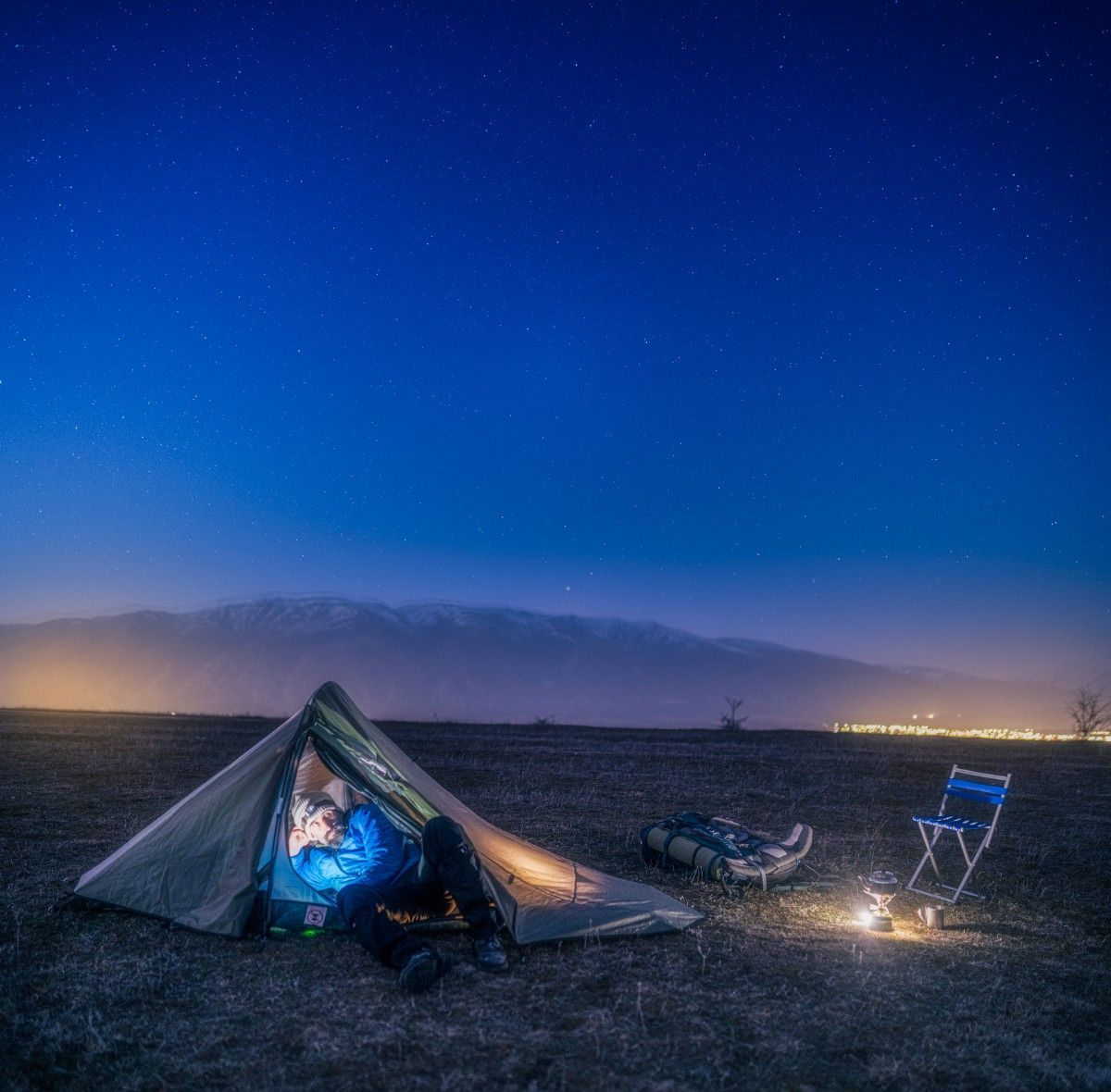 A person in their one man tent at nighttime 