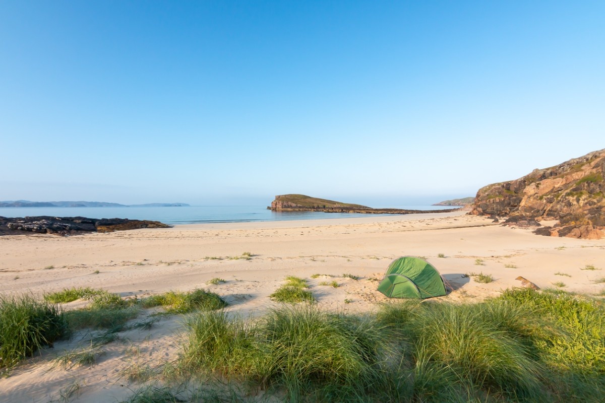 An image of a beach in the UK with a tent pitched