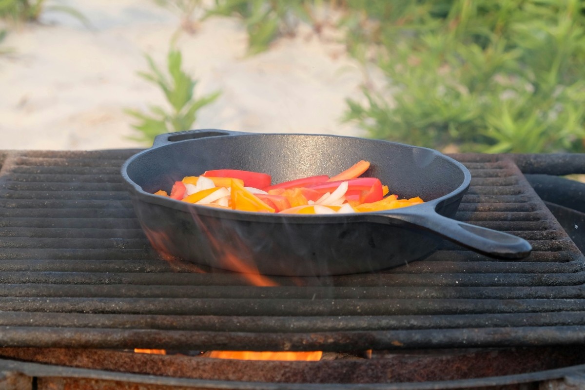 Vegetables being sauteed in a pan at a campsite