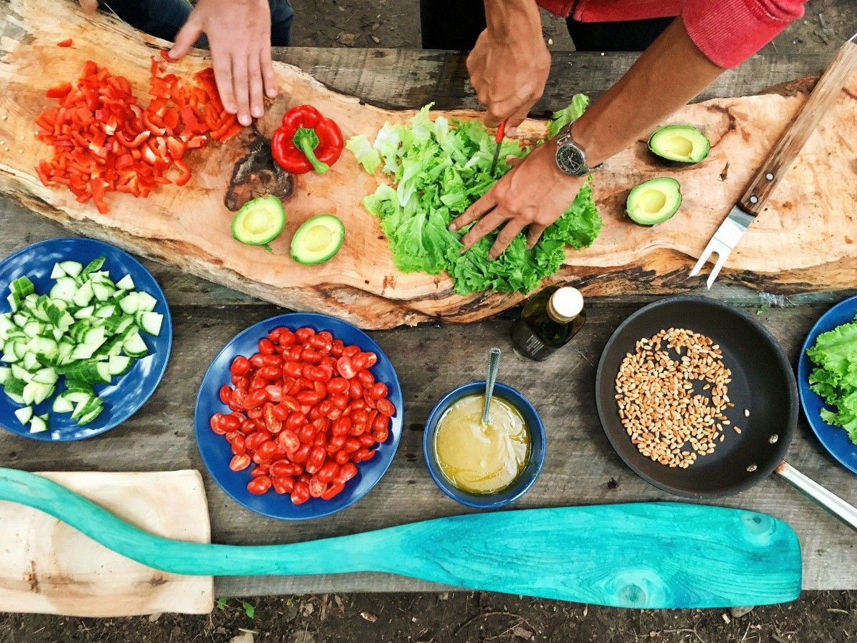 People prepping a vegetarian meal at a campsite 