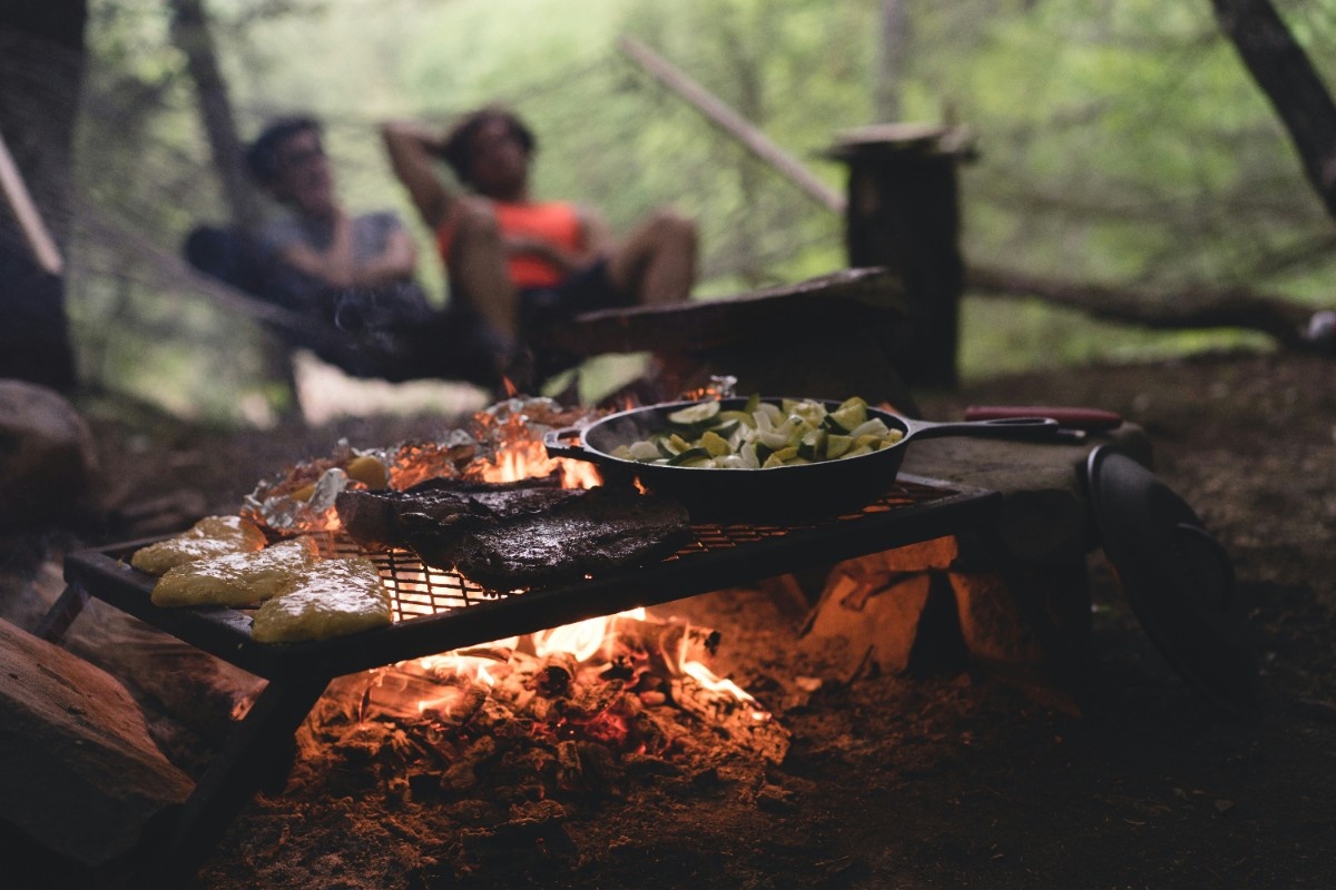 An image of a pan over a fire cooking camp recipes