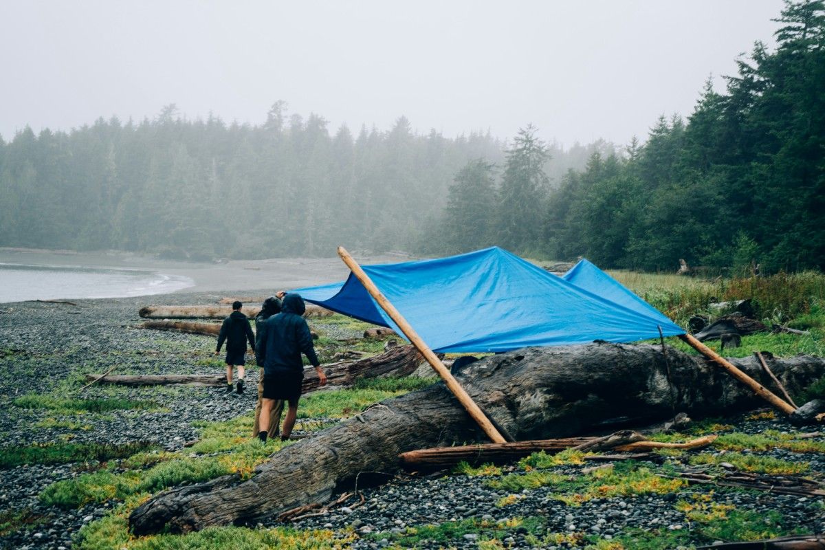 People with a tarp in the rain 