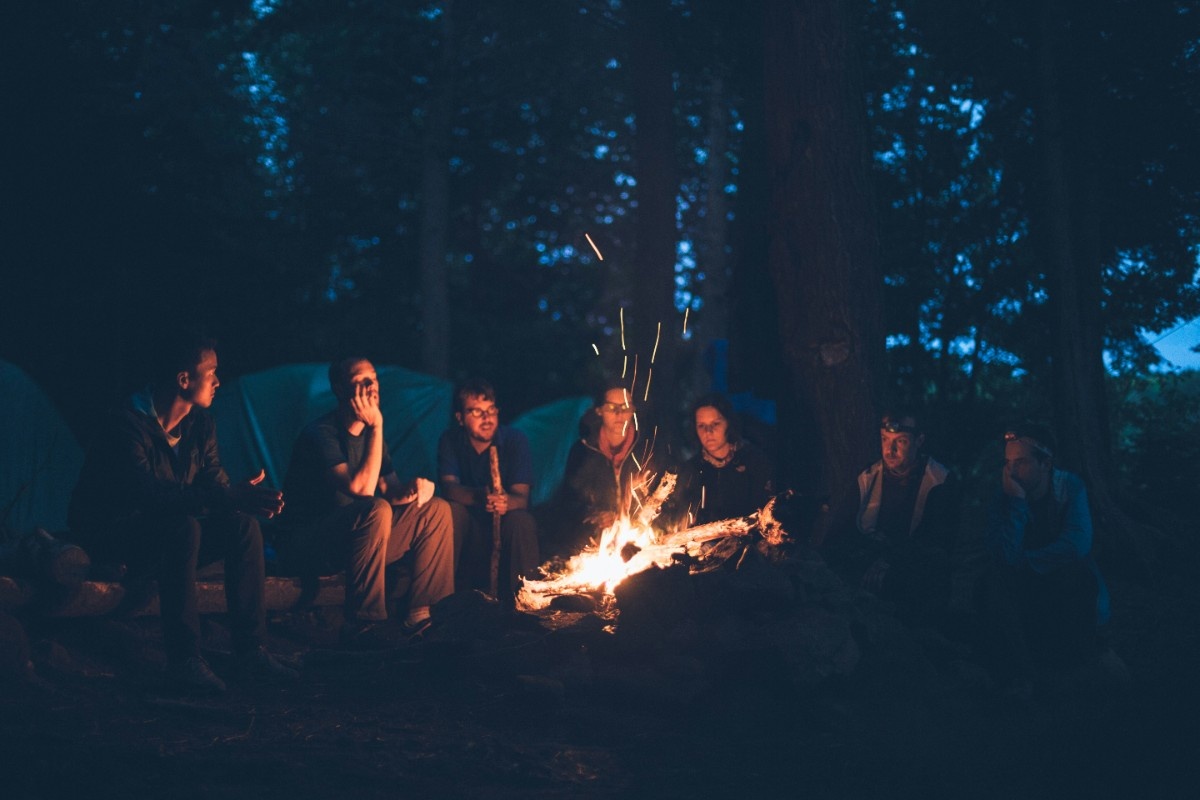 People sat around a campfire at the wild camp site 