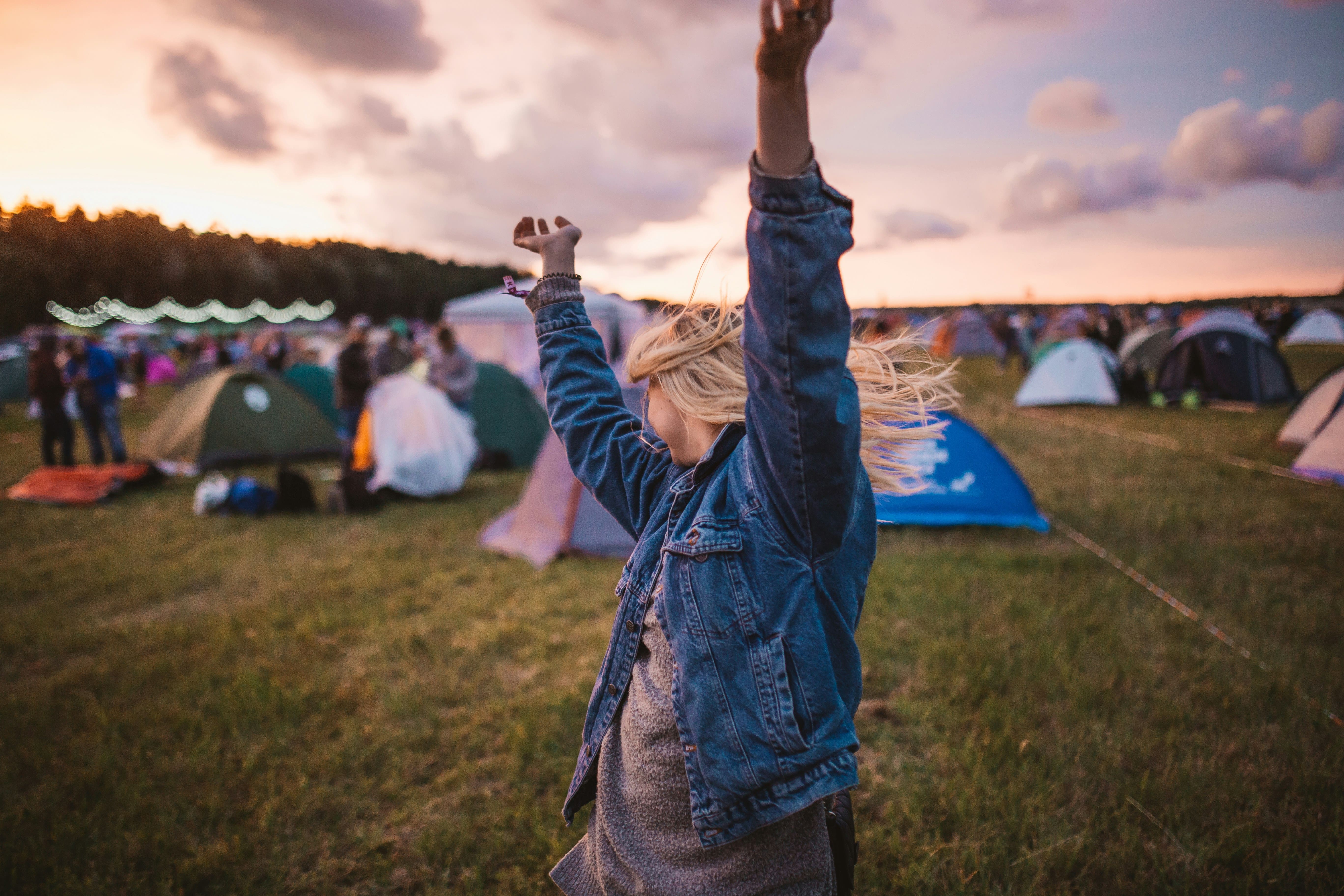 A person holding their phone up to record the stage in a festival crowd 