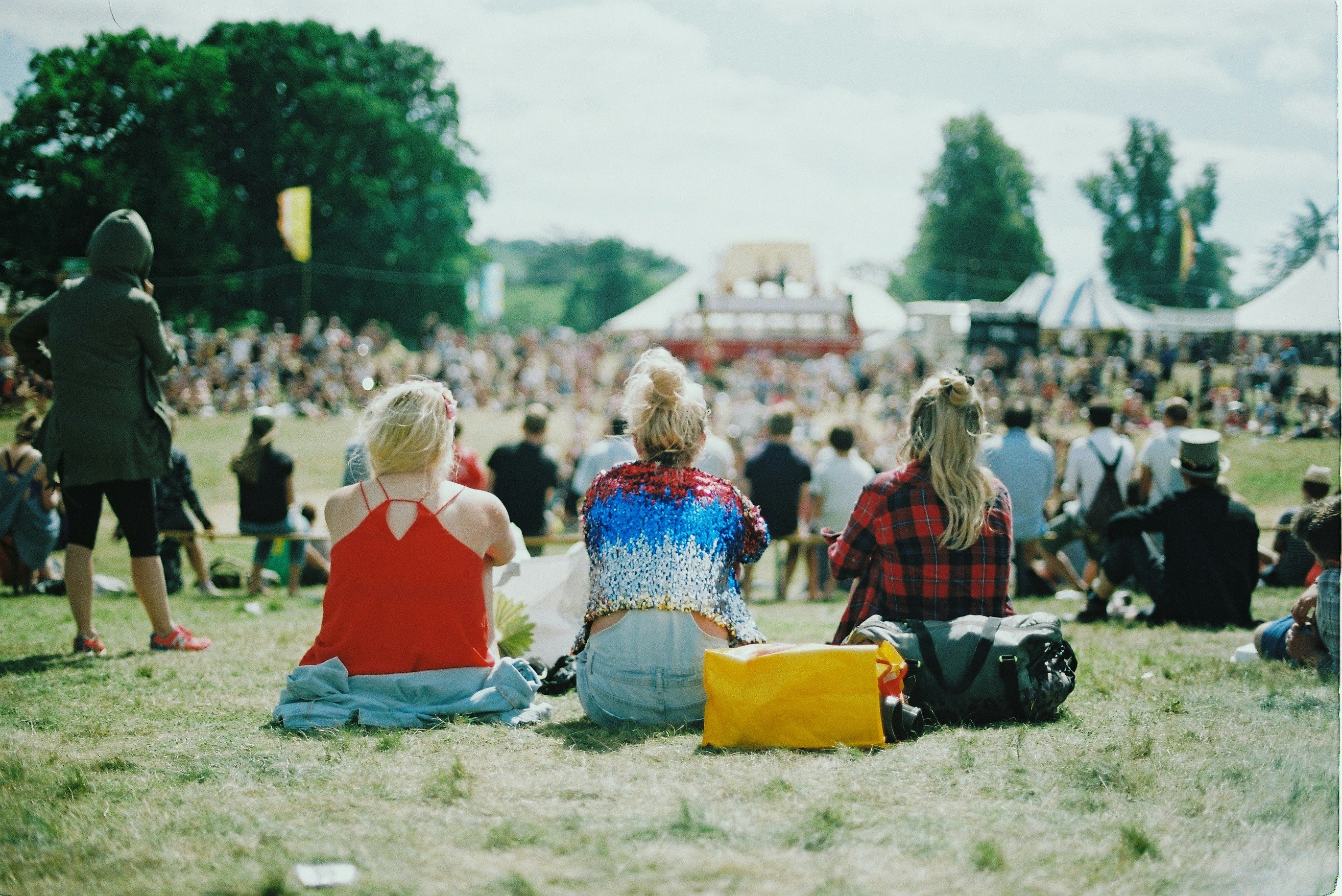 A person holding their phone up to record the stage in a festival crowd 