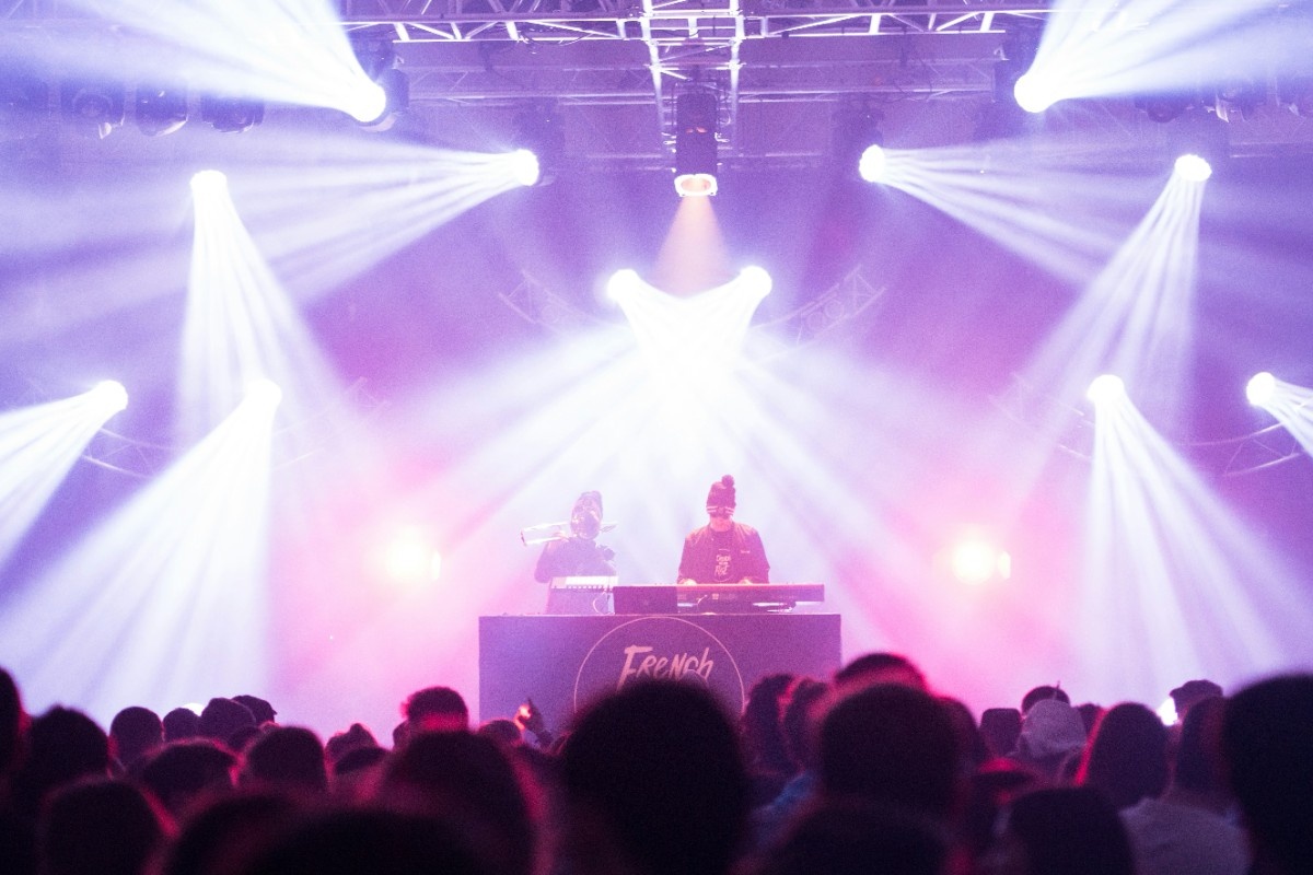 A DJ playing at Creamfields North with purple lights shining over the stage 