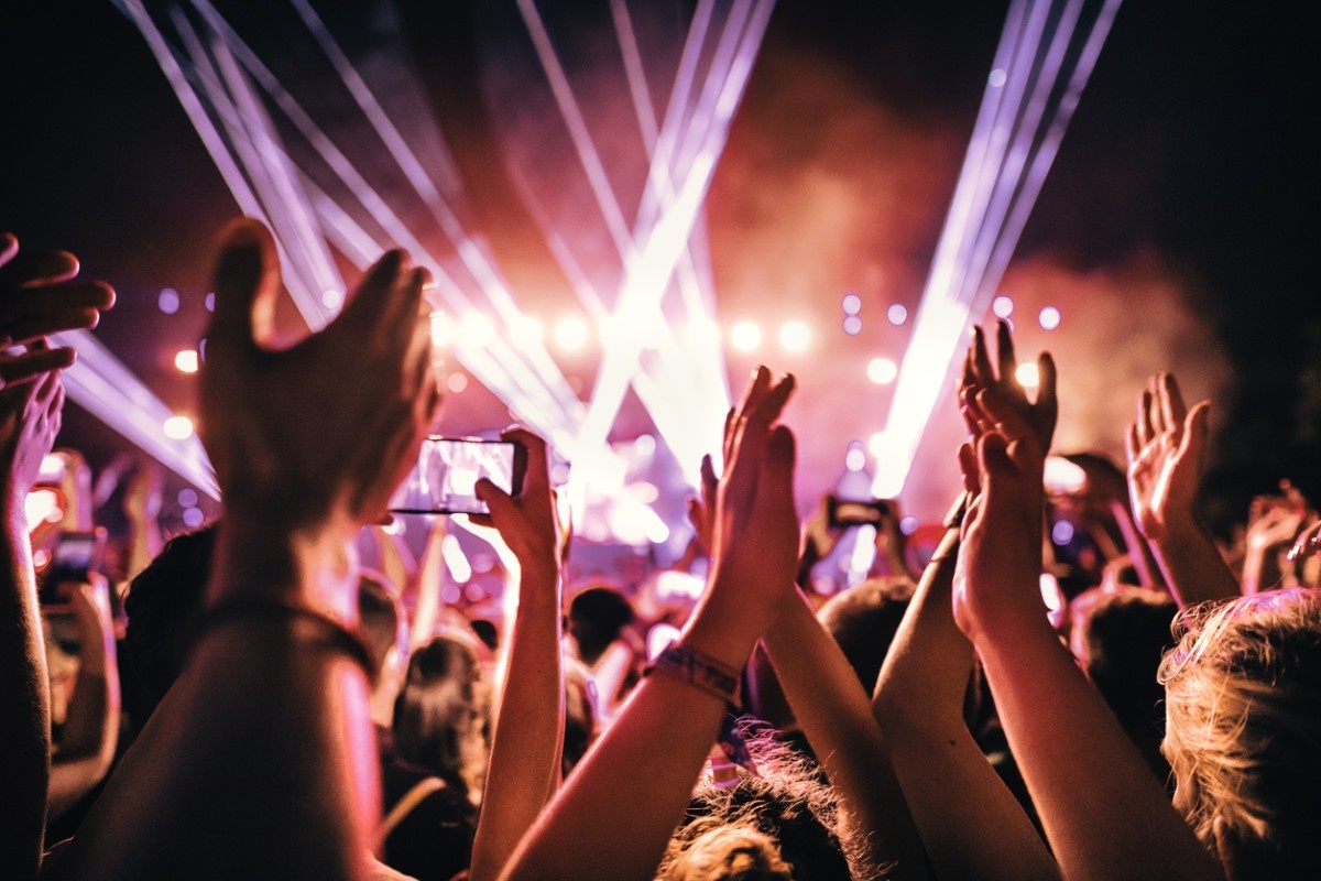 A group of people with their hands in the air in a crowd 