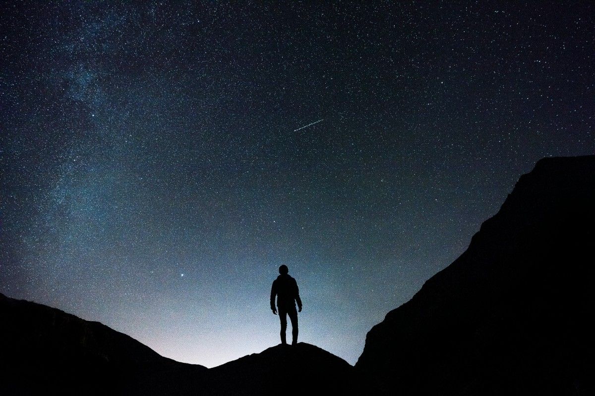 A person stood looking up at the night sky 