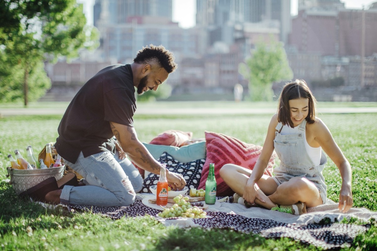 A couple having a picnic in the park with cushions 