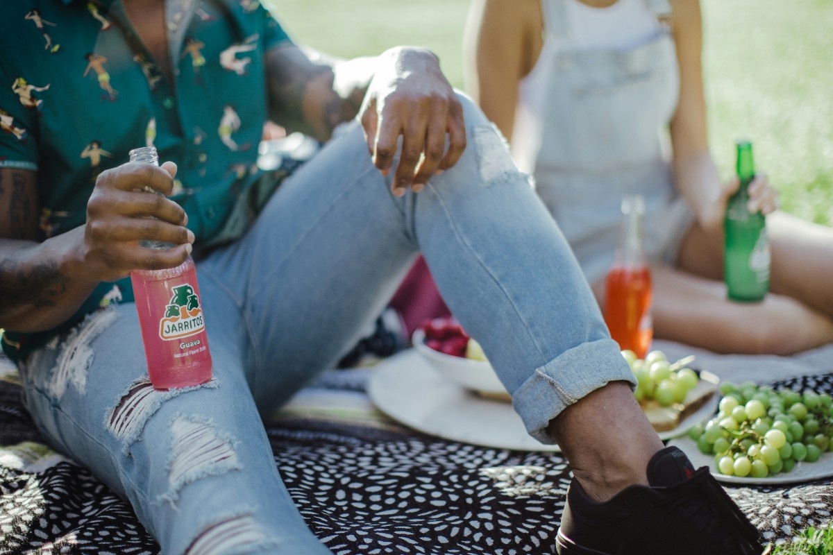 A man sat with a drink at the picnic