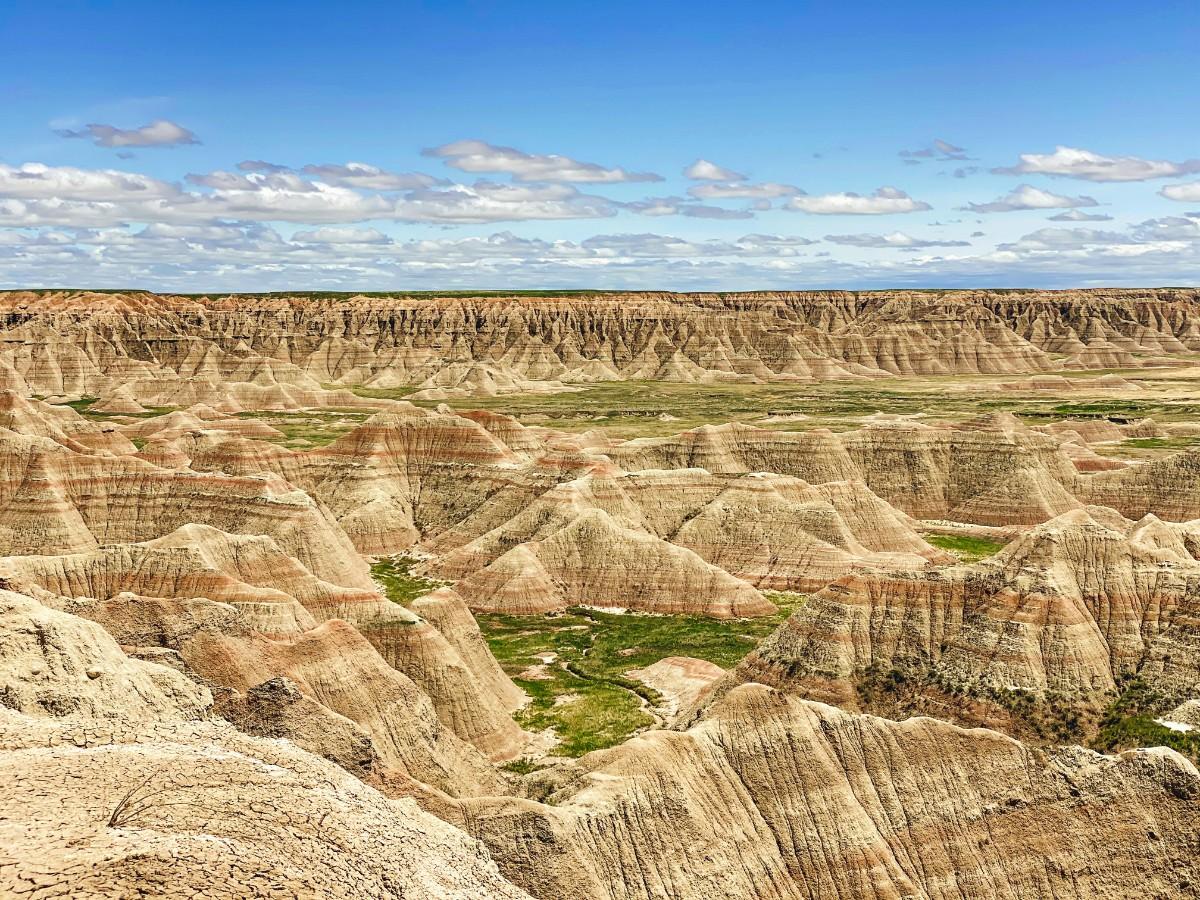 Green fields running through the rock formations of Badlands National Park