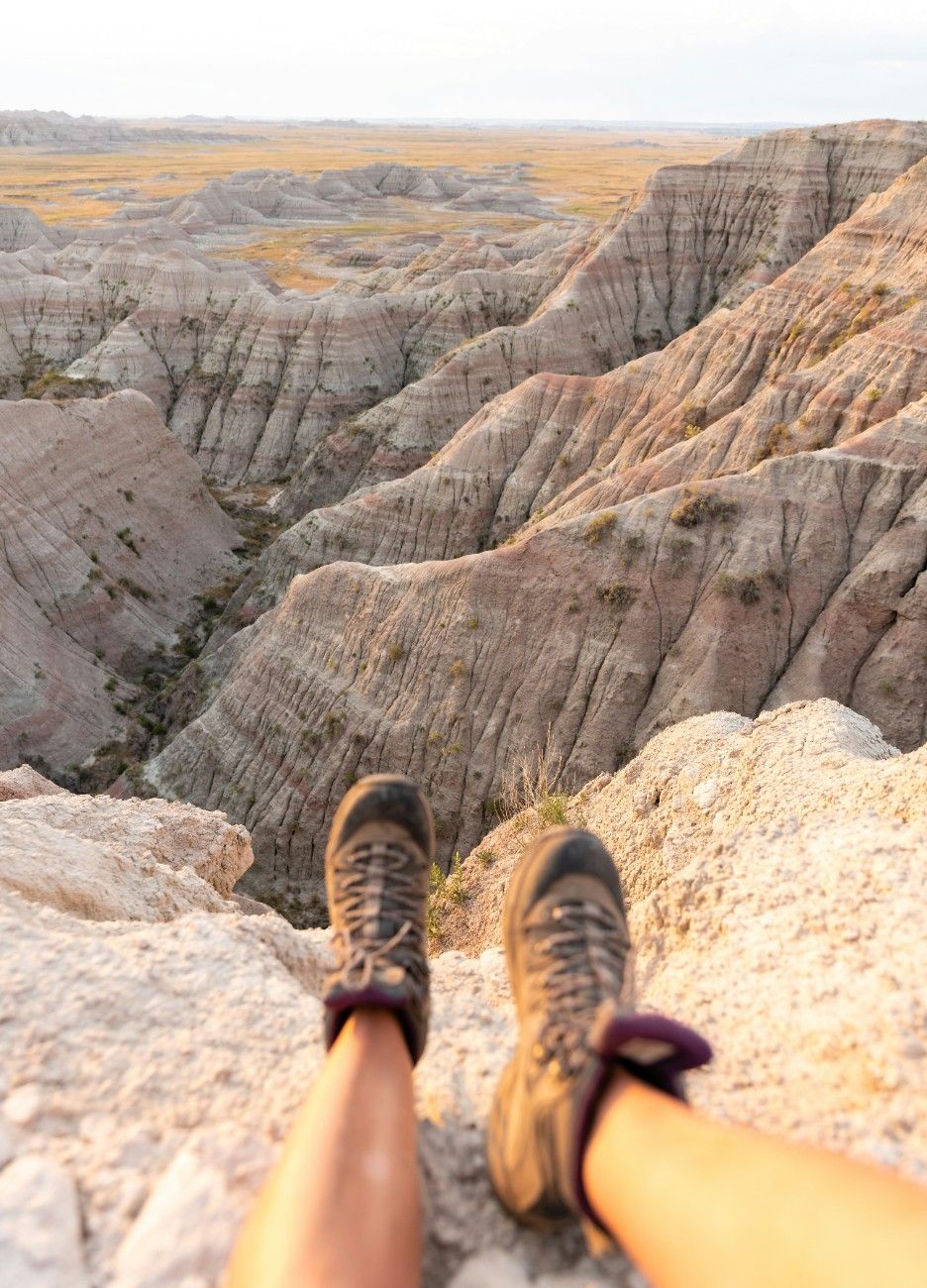 An image of a person sat on the edge of a rock in Badlands