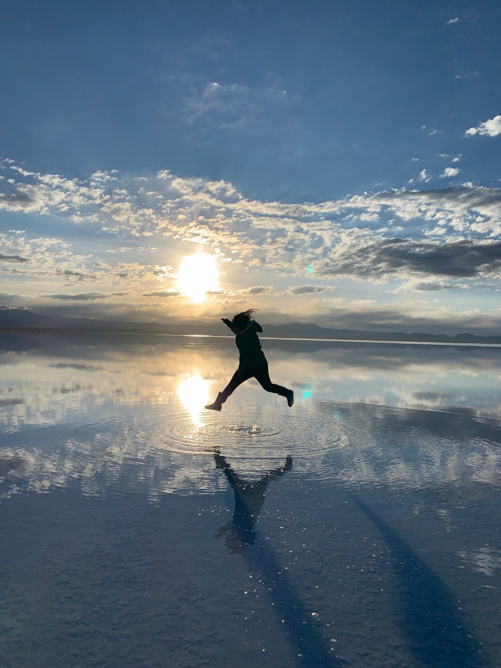 A person jumping on the Salar de Uyuni salt flats in Bolivia