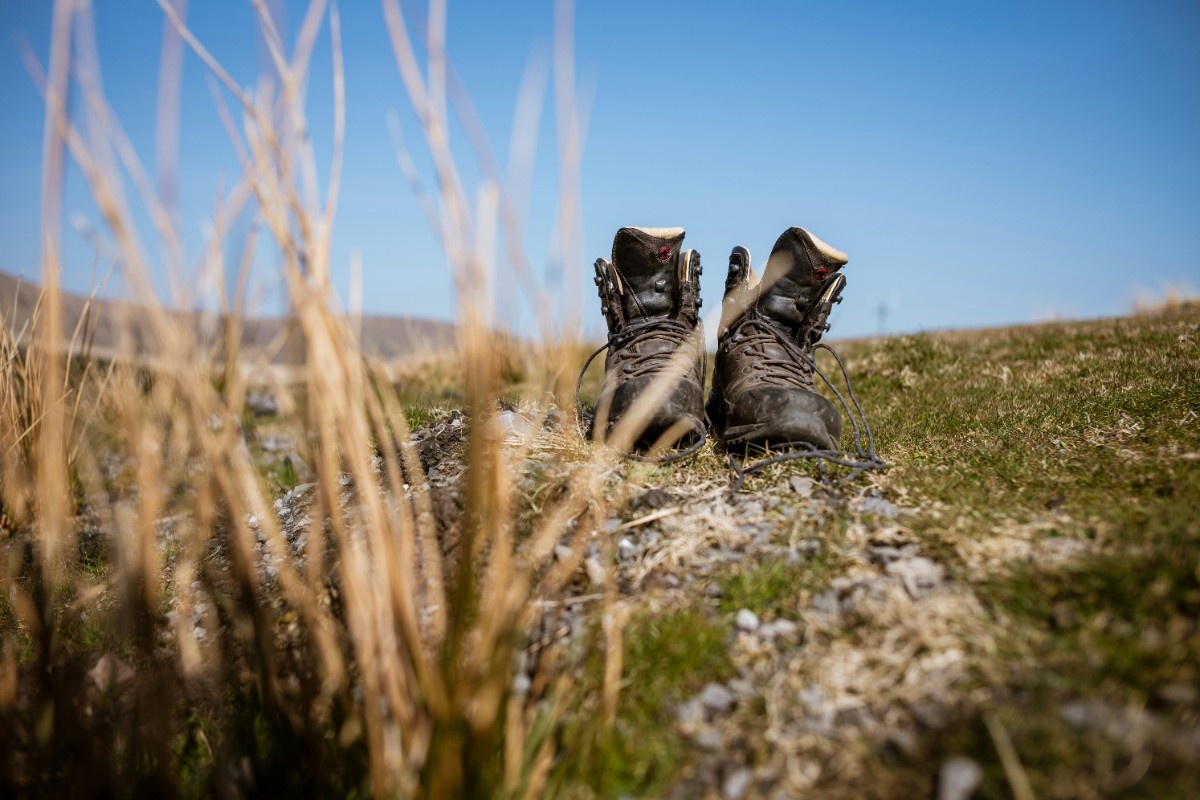 Some hiking boots on a rock in a field in Brecon Beacons