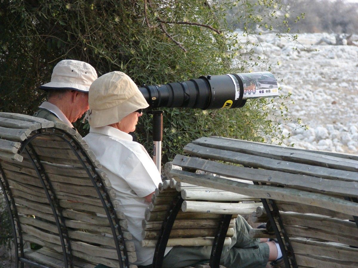 Wildlife photographers on Etosha National Park by a watering hole