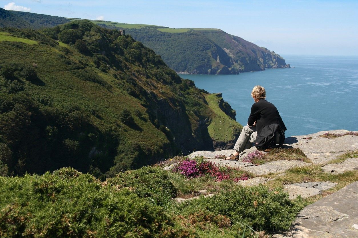 A woman sat on the edge of an Exmoor Cliff