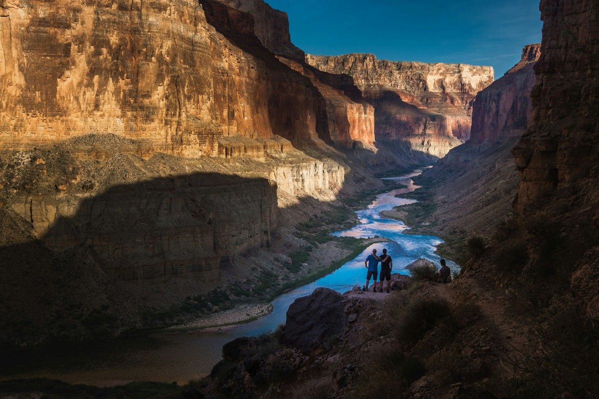 A couple looking out at the Colorado river, running through the Grand Canyon National Park 