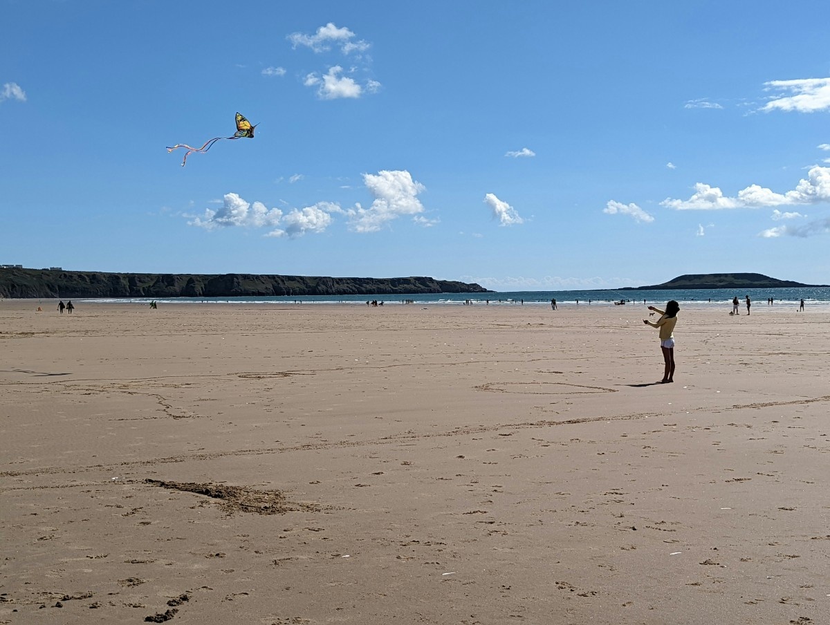 A person flying a kite on Llangennith beach