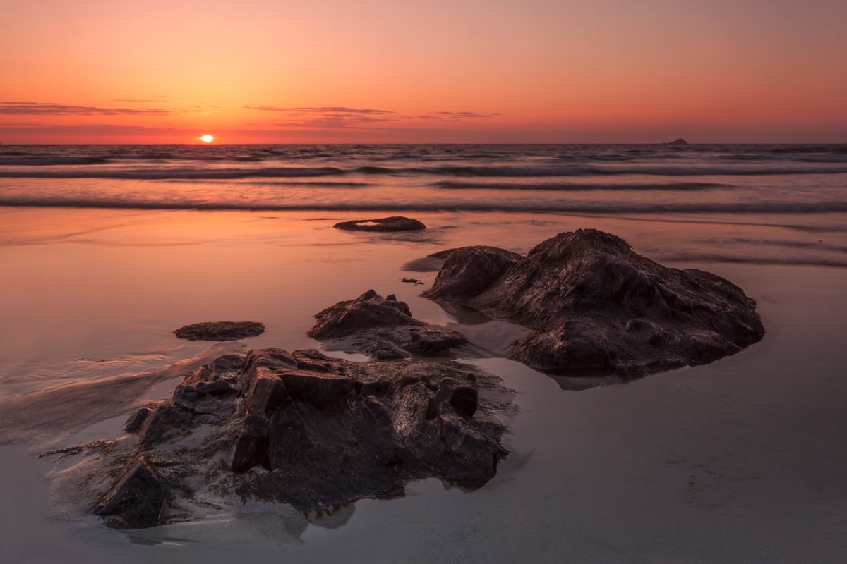 The sun setting on the rocks in Sennen Cove