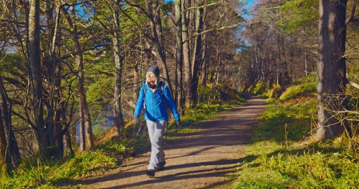 A woman walking along a trail on the Speyside Way