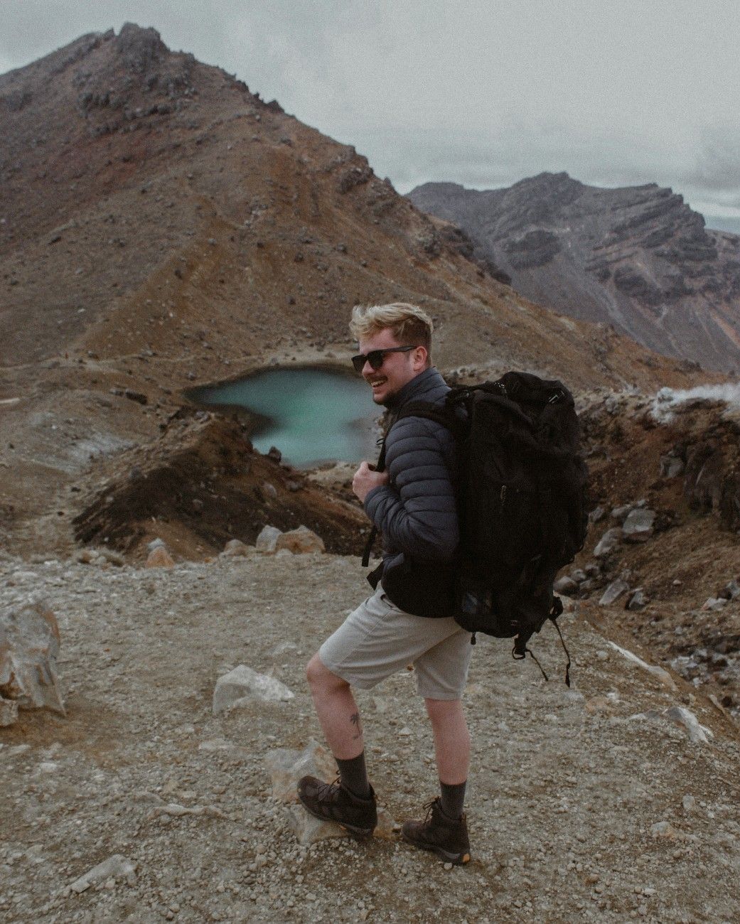 A man stood above a lake on the Tongariro Alpine Crossing