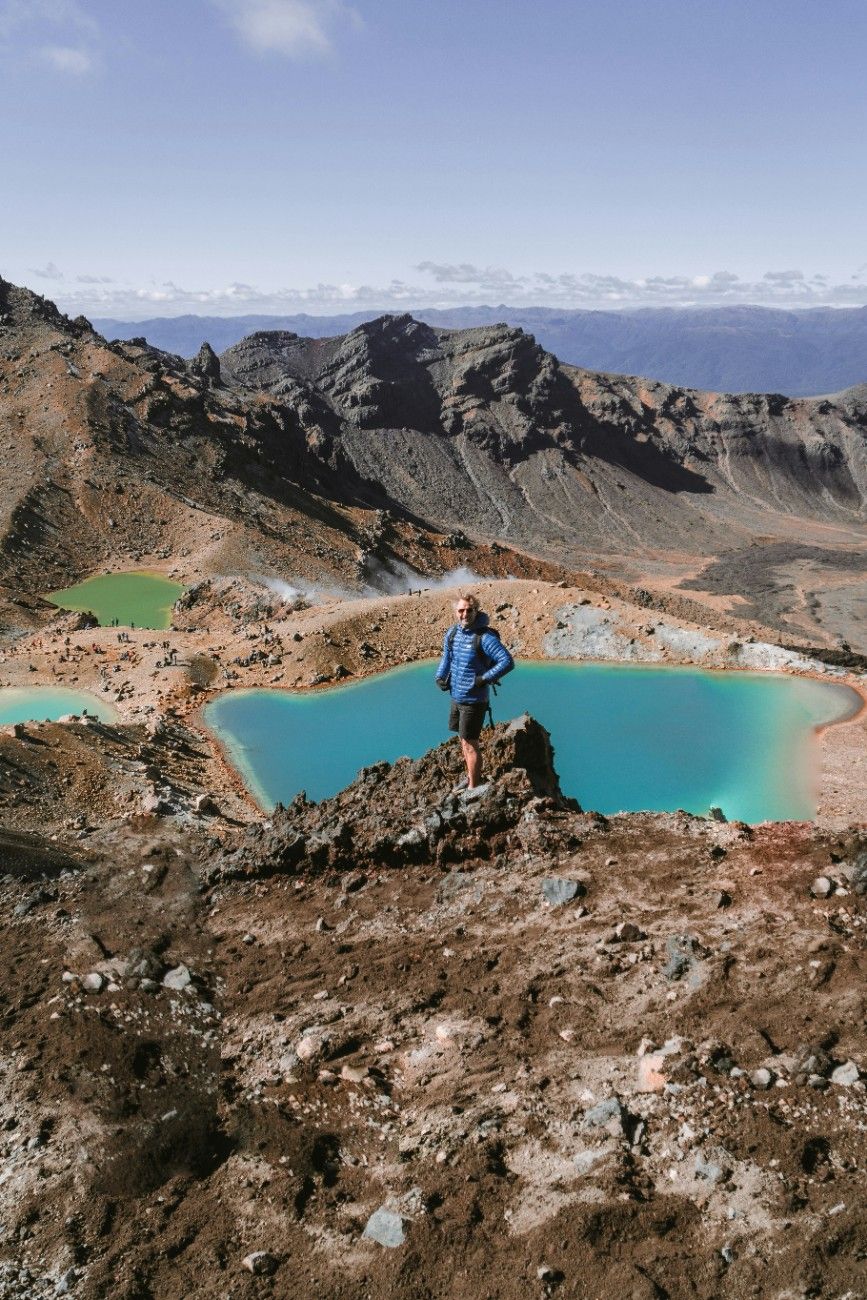 A man stood above a lake on the Tongariro Alpine Crossing