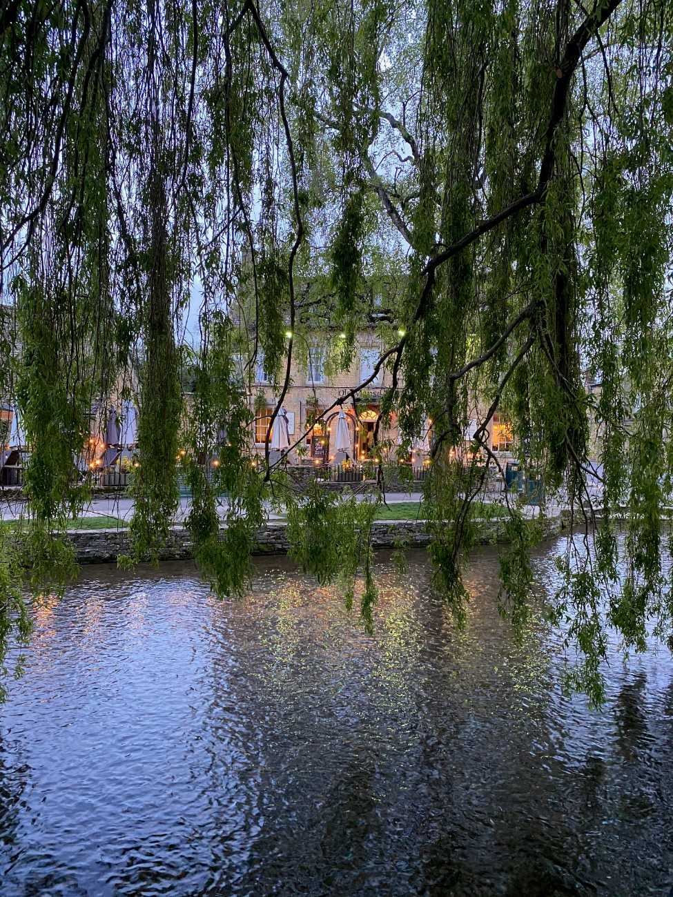 A pub in Bourton on the Water on the river, taken through the trees 