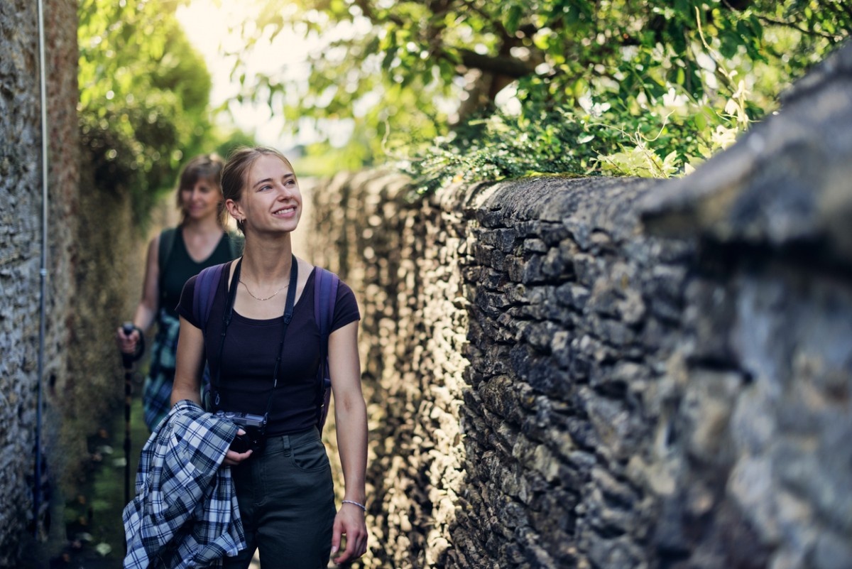 A mother and daughter walking by a stone wall in Stow-on-the-Wold