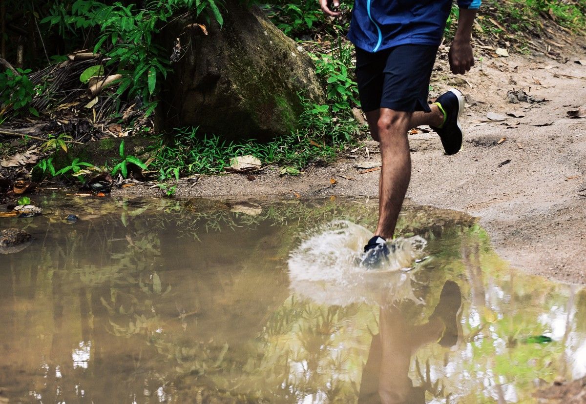 A person running through a puddle in the rain