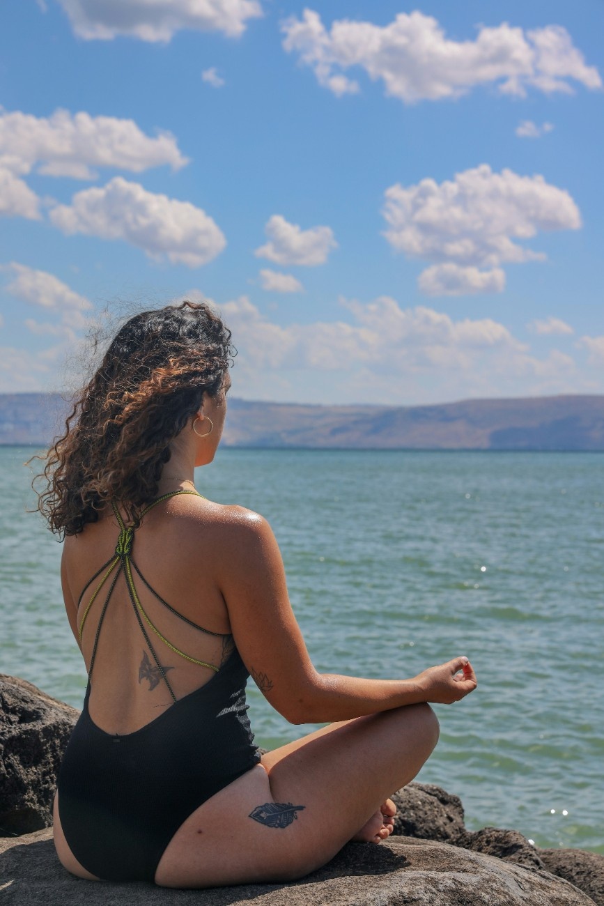 A woman meditating by the sea