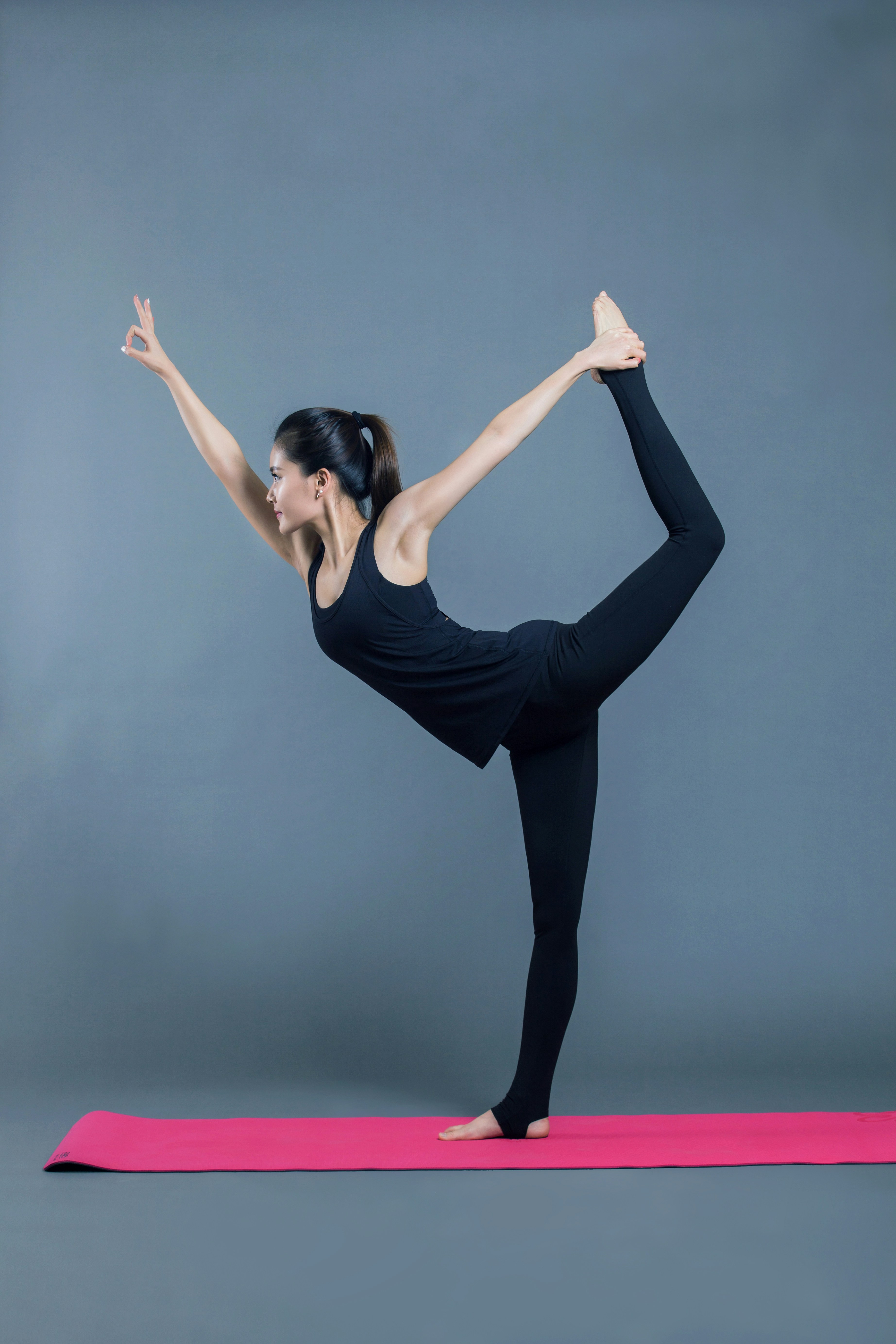 A person performing a dancers pose in a yoga practice