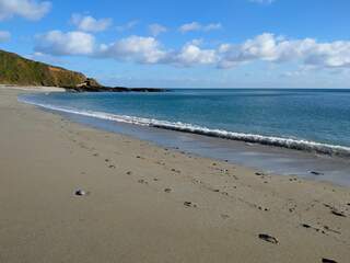 Footprints in the sand on Par beach, Cornwall on a sunny day in winter