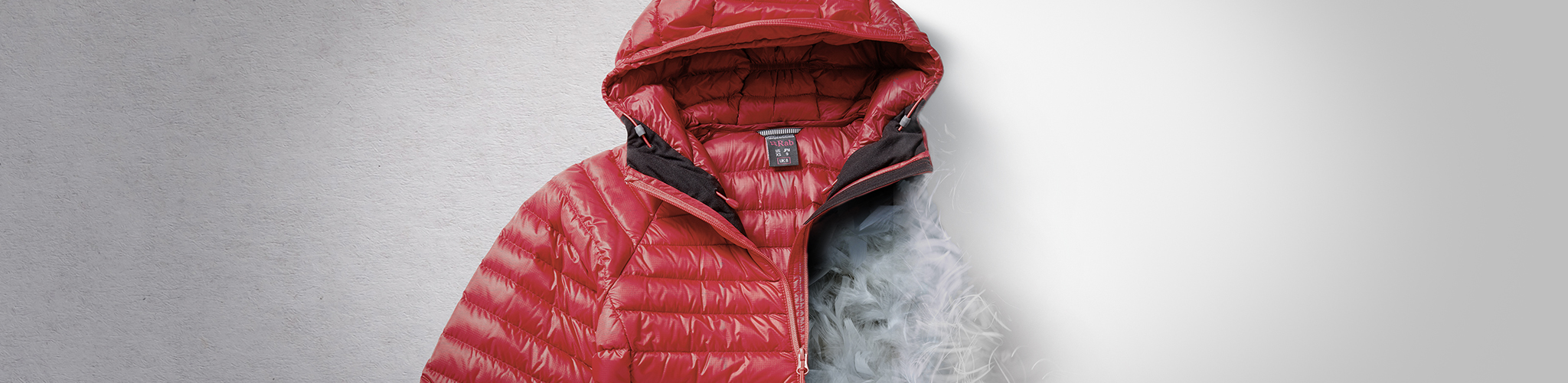 A red insulated jacket, one half of which is just inside insulation without the outer layer.