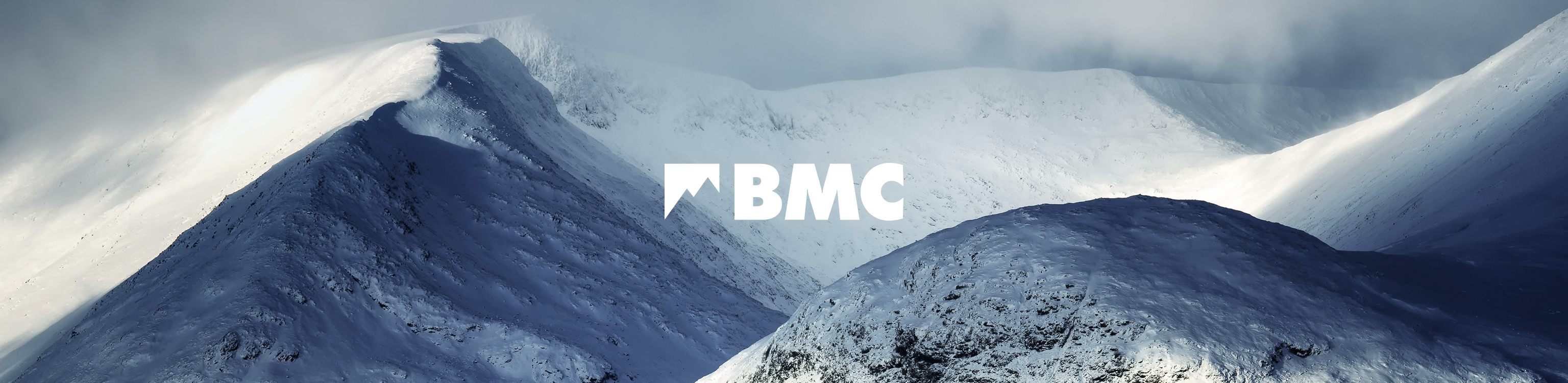 Mountains, covered in snow, with the BMC brand logo in the middle