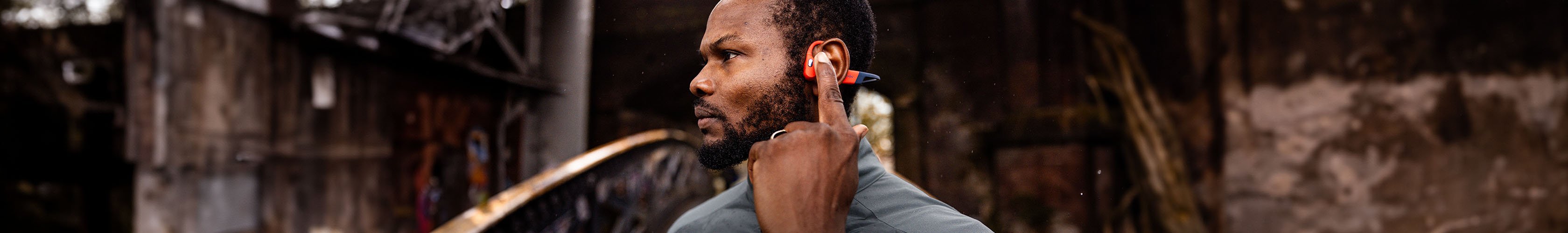 Shop electronics new season. A man adjusting his heahphones, wearing a watch on his wrist