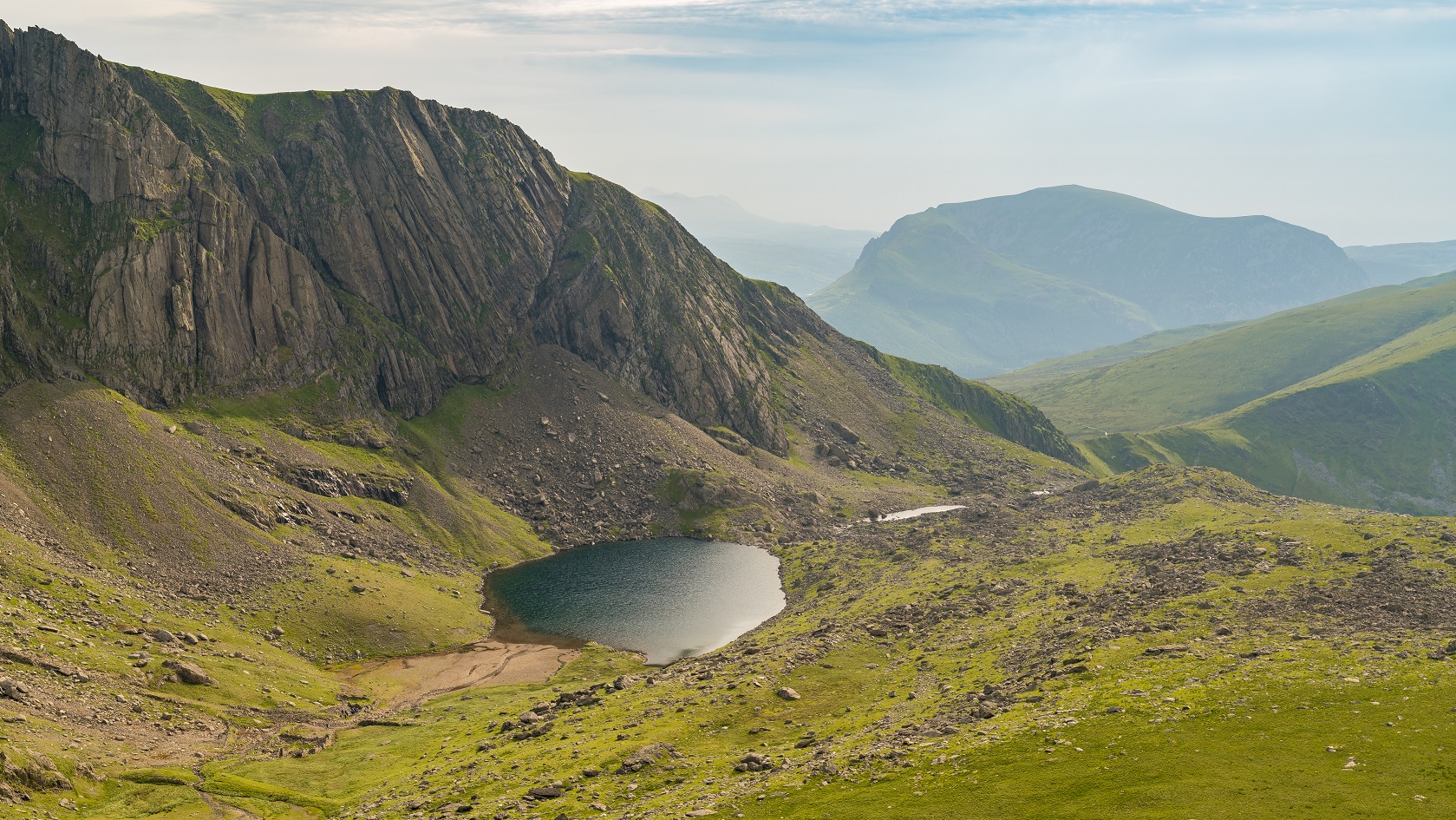 Walking down from Mount Snowdon on the Llanberis Path, Snowdonia, Gwynedd, Wales, UK - looking at Llyn Du'r Arddu and Clogwyn Coch